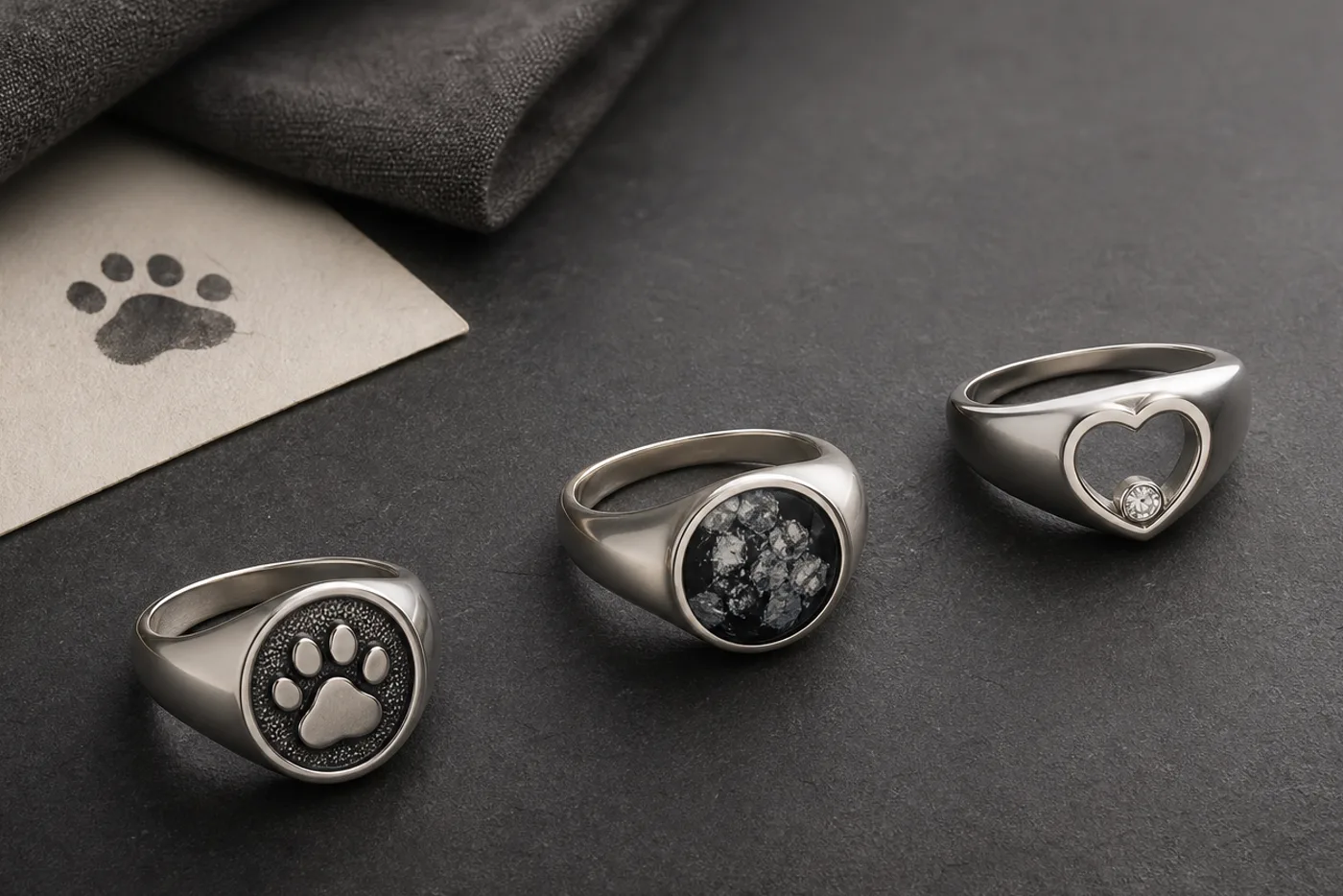 Custom dog memorial jewelry shown with a silver ring, collar tag, paw print card, and keepsake photo